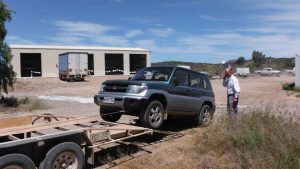 Ray watches his vehicle being loaded on a trailer at Owieandana